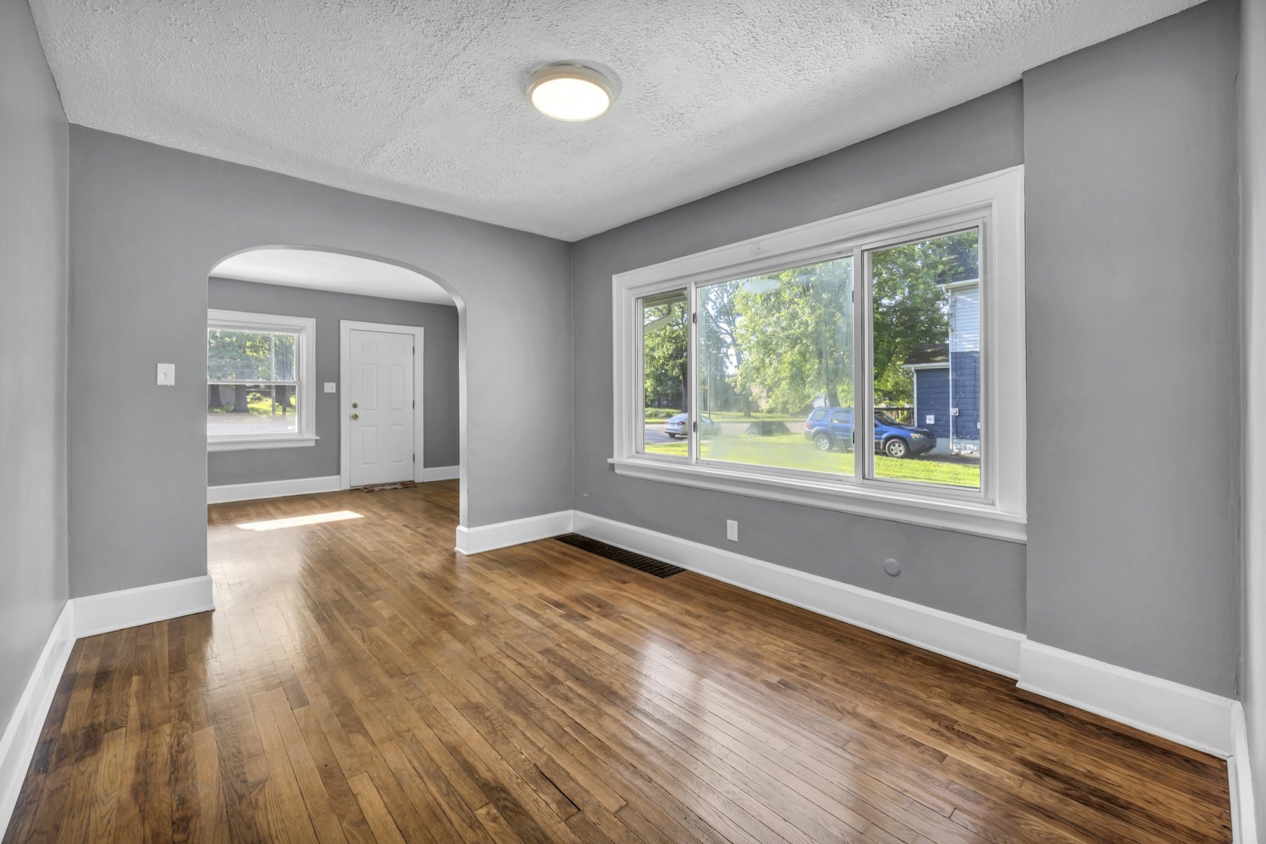 Bright room with warm hardwood floors and white baseboards