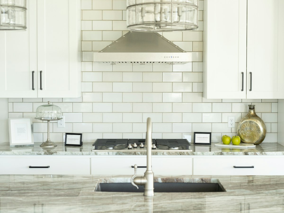 Kitchen with a white subway-tile backsplash above the counter and sink